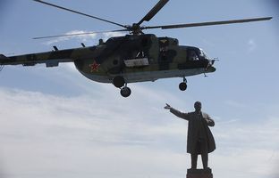 El helicóptero militar en el que viajaba Rosa Otunbáyeva, a punto de aterrizar en la plaza central de Osh junto a una estatua de Lenin